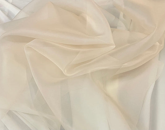 Different fabrics. Organza, chiffon, silk, jacquard are spread out on the  table. View from above. Beige silk, brown organza, golden mesh fabric for  sewing clothes. Stock Photo